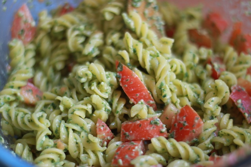 A pasta dish with pesto and tomatoes